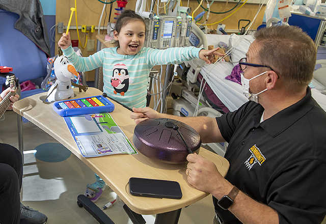 Maya and her father, Brent, play music together while she is at the hospital.
