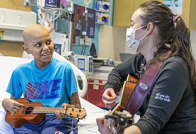 Raphael and his music therapist with their guitar and ukulele.