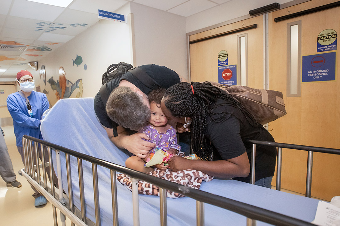 Jessica and Lee "sandwich" their daughter Kylie into a kiss before her procedure at Johns Hopkins All Children's.
