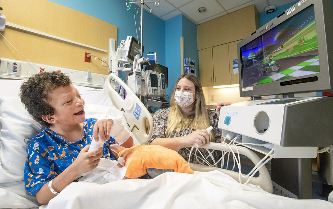 Julian plays a video game with gaming specialist Brittany Bordeaux at Johns Hopkins All Children's.