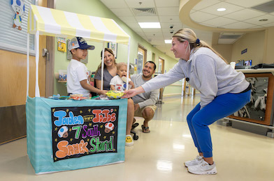 Jaden, JoJo and their mom and dad at their snack stand in Johns Hopkins All Children's