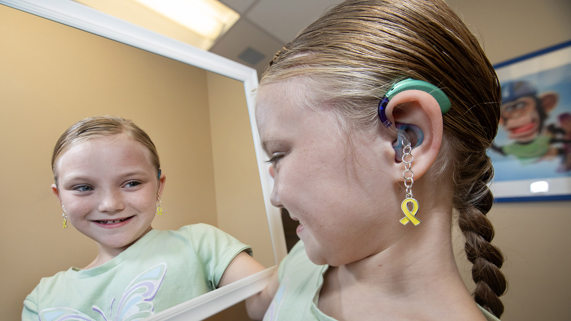 Audrey showing the jewelry she has made for hearing aids.