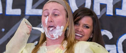 A child life team member demonstrating an activity on another member; painting her face with shaving cream.