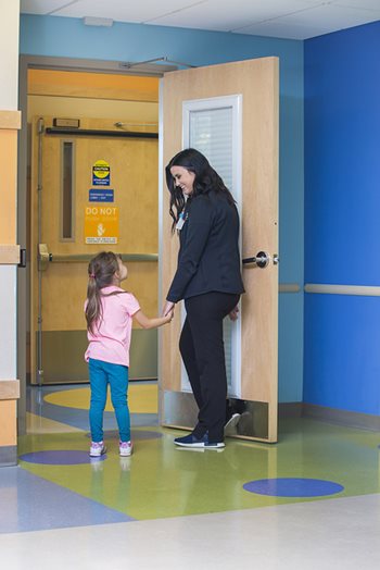A nurse walking a child into the emergency department.