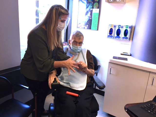 Lora Clawson helping a patient use a spirometer