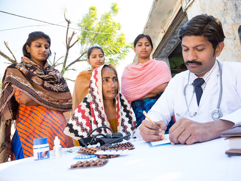 Doctor helping patient with family nearby