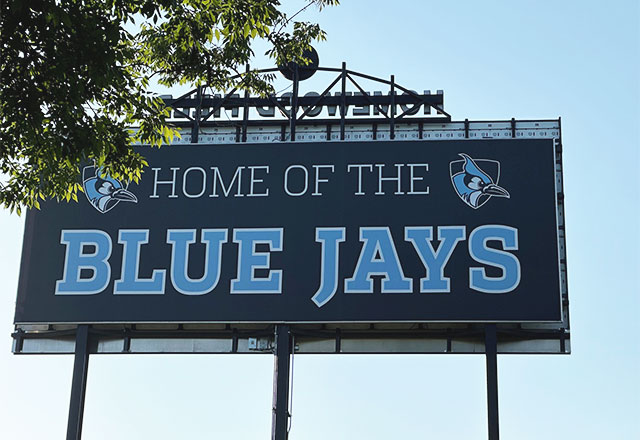 Picture of a sign saying "Home of the Bluejays" on the Homewood campus.