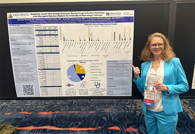 Dr. Susanne Muehlschlegel standing in front of a poster presentation.
