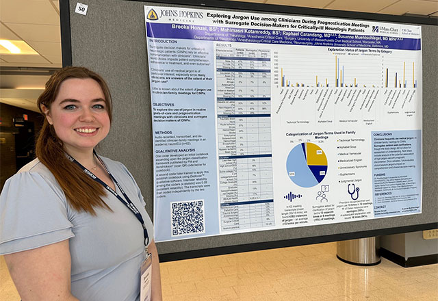 Brooke Honzel standing in front of her poster presentation.