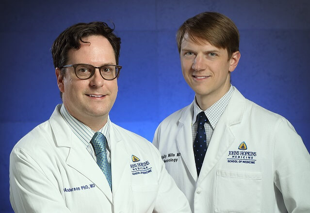 Sr. Mills and Dr. Anderson standing next to each other, wearing white coats