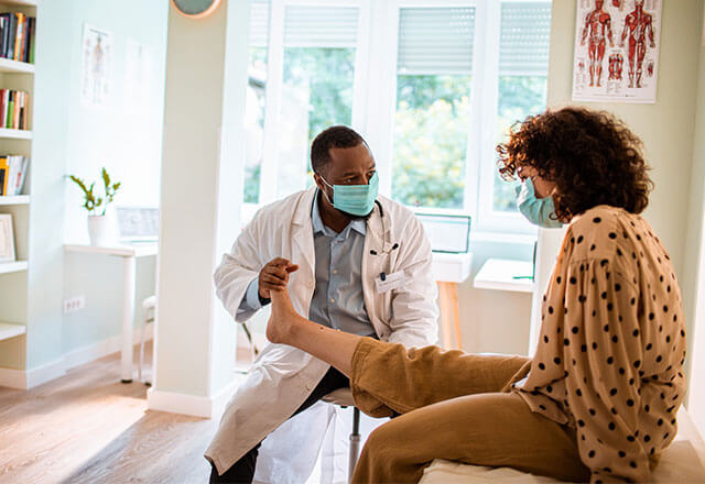Doctor helps manipulate patients leg