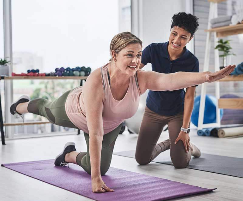 doctor assisting patient doing yoga