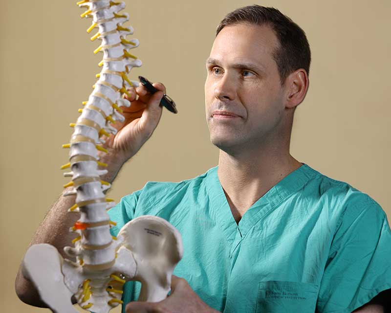 Dr. Witham examining a 3 D spinal model