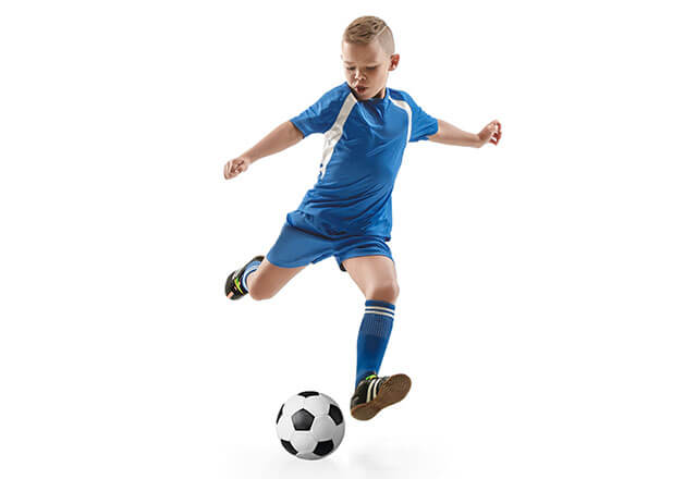 little boy in a blue uniform playing soccer