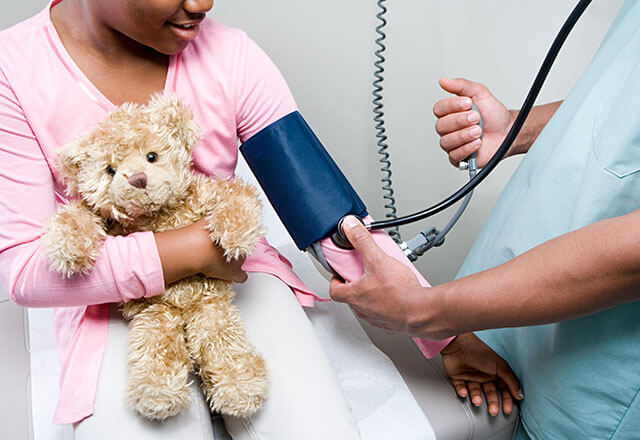 doctor taking a little girl's blood pressure