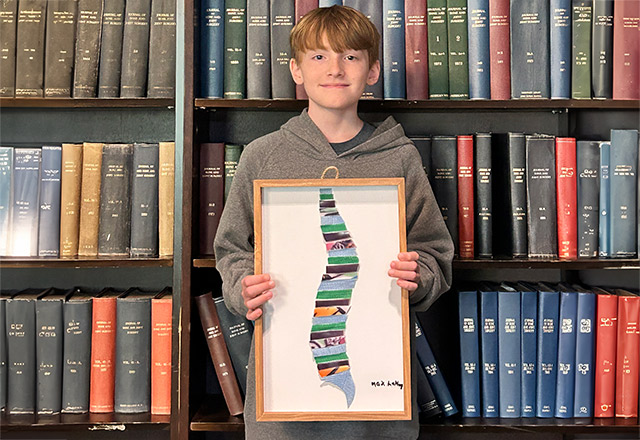 Max LeMay holding his artwork