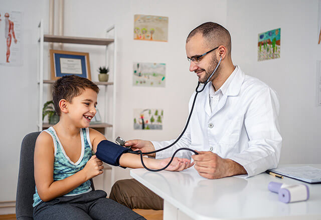 a pediatrician takes a child's blood pressure