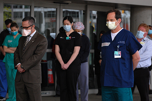 Masked providers bow heads in a moment of silence