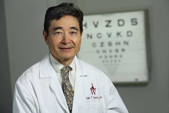 Doctor Handa standing in front of a Snellen chart