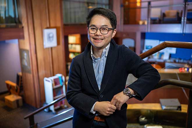 Doctor Liu standing along a sleek staircase