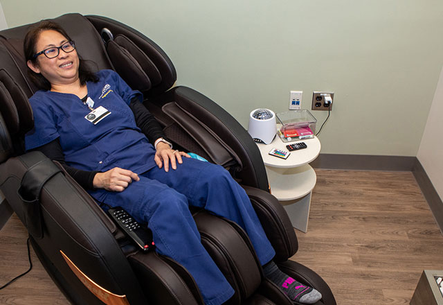 JHM employee enjoying a massage chair in the RISE restore room
