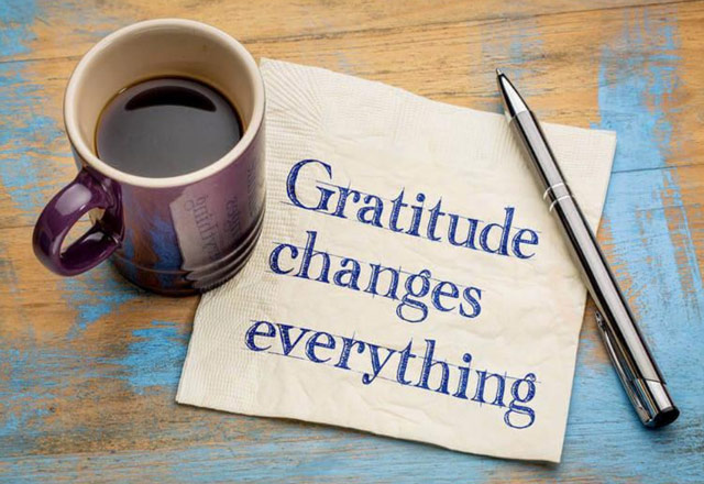 A note on a desk reading, "Gratitude changes everything"