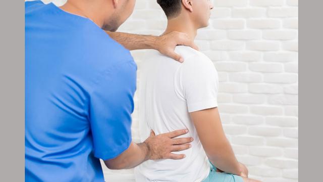 Physical therapist holding patients' back