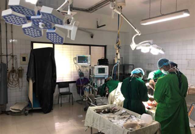 Doctors standing around an operation table.