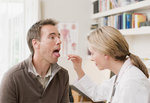 doctor examines patients throat