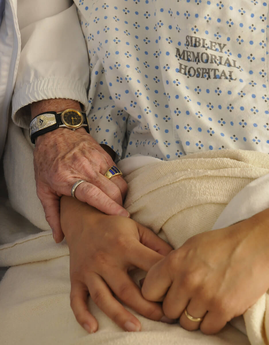 closeup of a chaplain holding a patient's hand