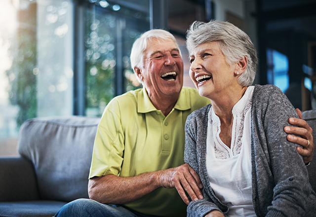 Older man and woman laughing and embracing