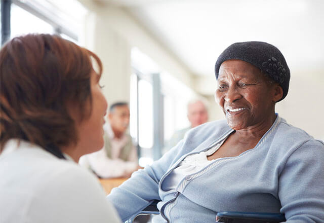 patient in a chair smiling at a caregiver