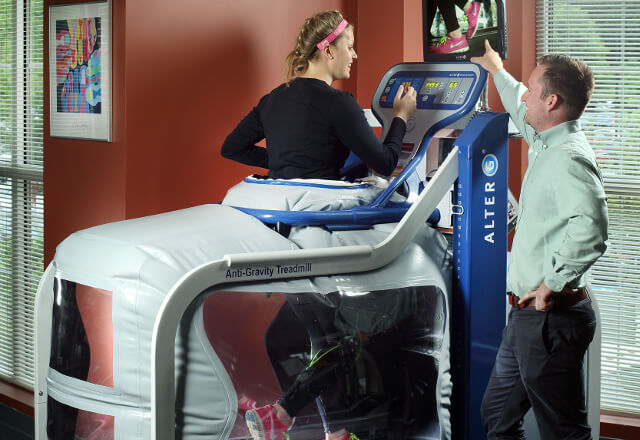 Provider working with a client in a zero gravity treadmill.