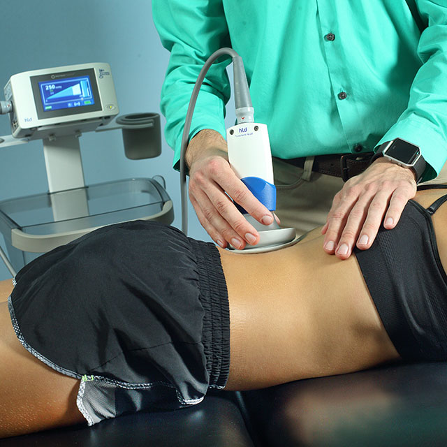 Therapist using a negative pressure machine on a patient's back.