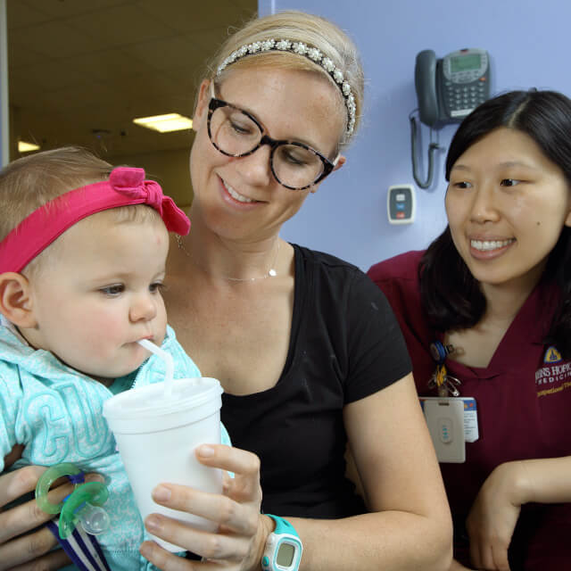 Pediatric occupational therapist observing mother feeding her baby