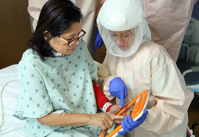 a therapist works with a COVID-19 patient in the hospital