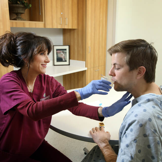 A speech-language therapist conducting a swallow test on a patient