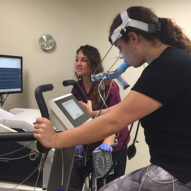 Therapist working with a patient on a performance testing machine.