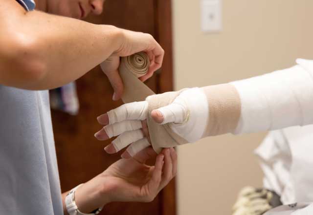 Bandaging a patient's arm.