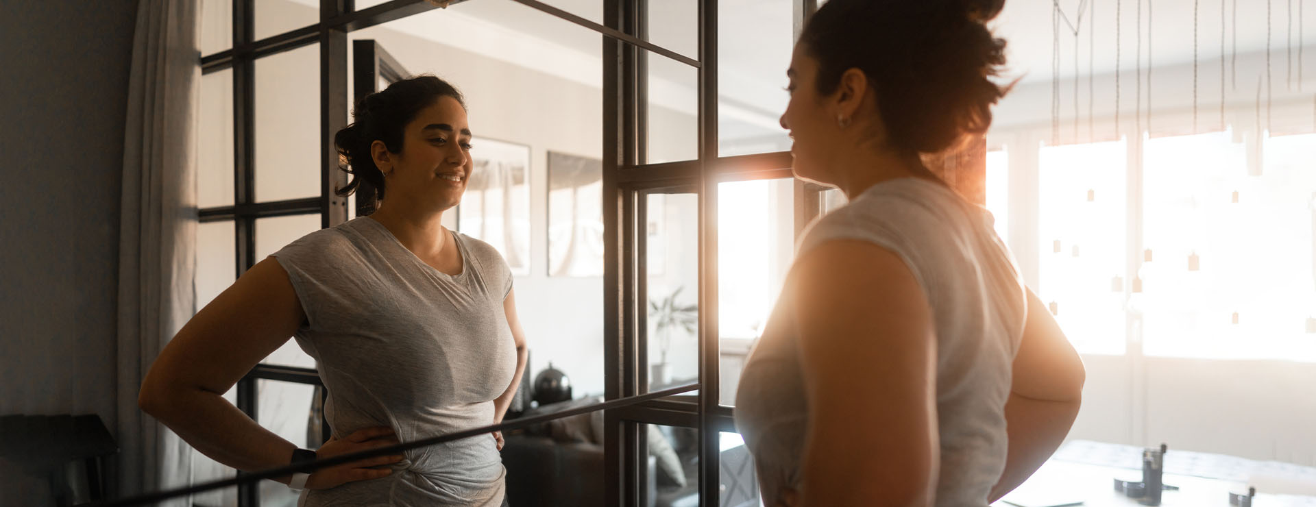 A woman looking happily into a mirror