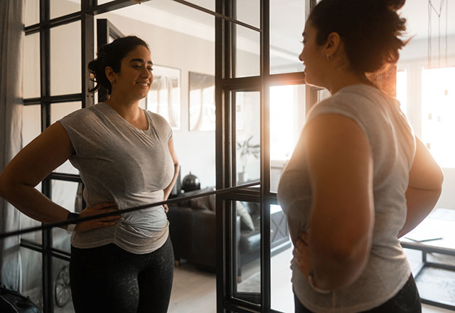 A woman looking happily into a mirror
