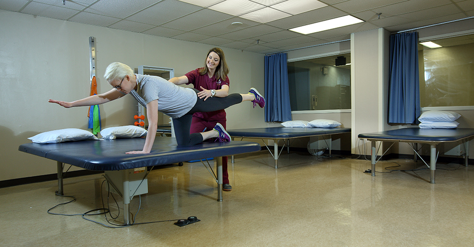 A physical therapist works with a patient.