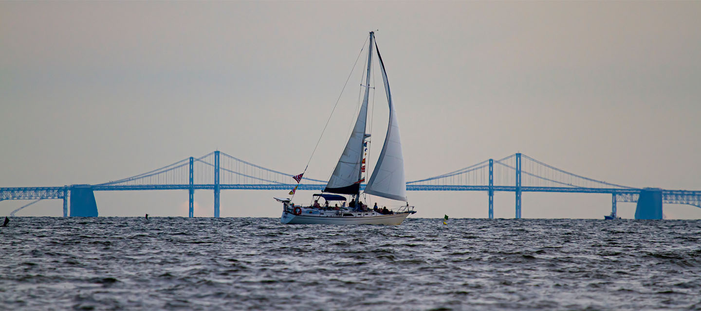 sailboat in front and bridge in background