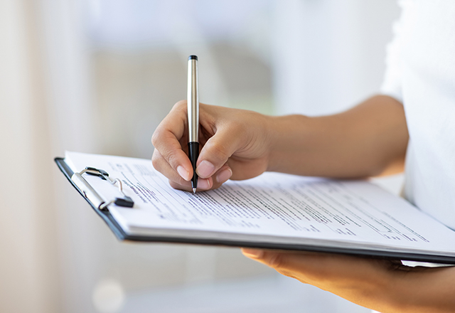 Holding clipboard and a pen in office