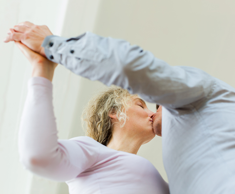 A senior couple dances together.