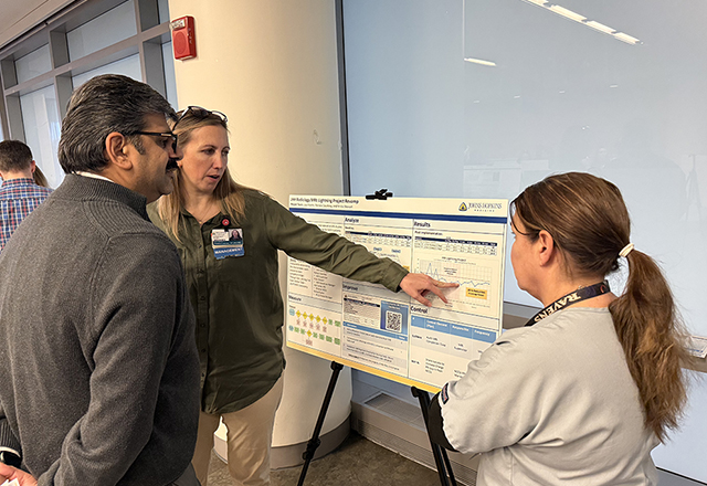 faculty looking at poster