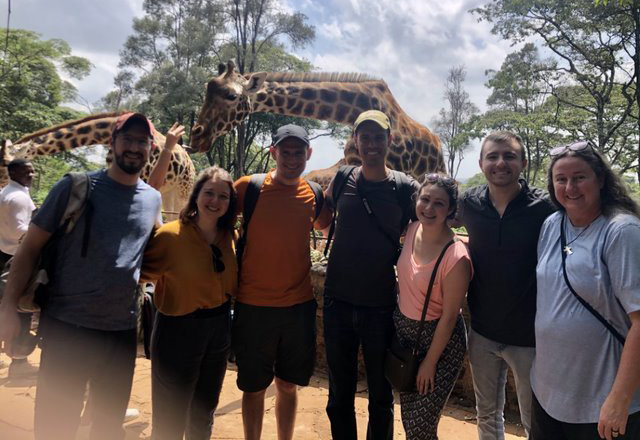 global health residents in Kenya, with a giraffe behind them