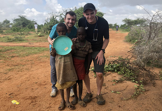 global health residents posing with a young Kenyan villager
