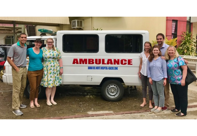 global health residents posing in front of ambulance