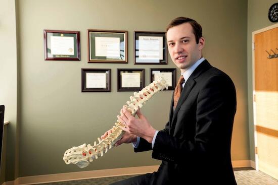 Neurosurgeon holding model of spine